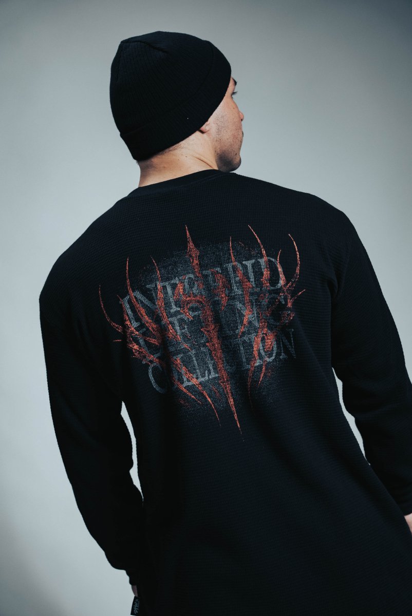 Person wearing a black long-sleeve shirt with red graphic design on the back against a gray background