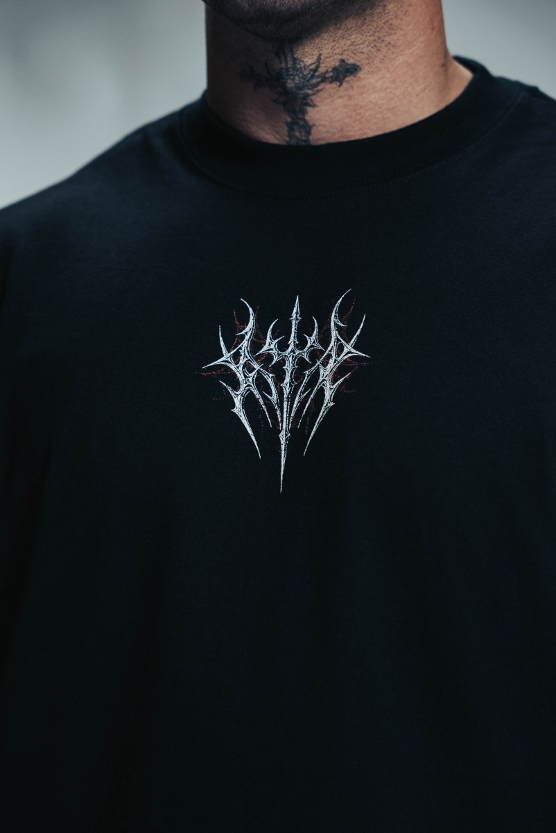 Black sweatshirt with a white embroidered logo on a blurred background