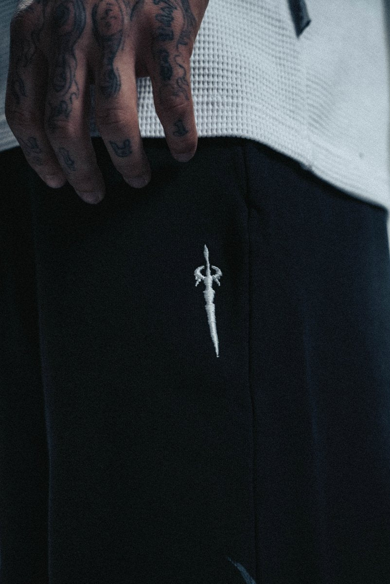 Black jacket with a white embroidered design on a dark background