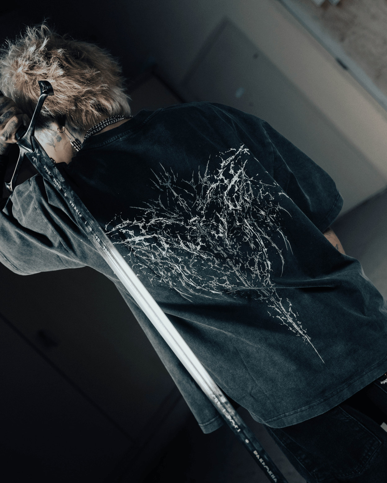 Person wearing a dark jacket with a floral design on a blurred background