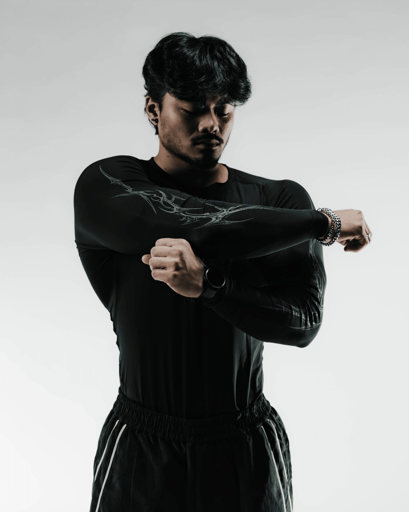 Person wearing a black outfit with a design on a plain background