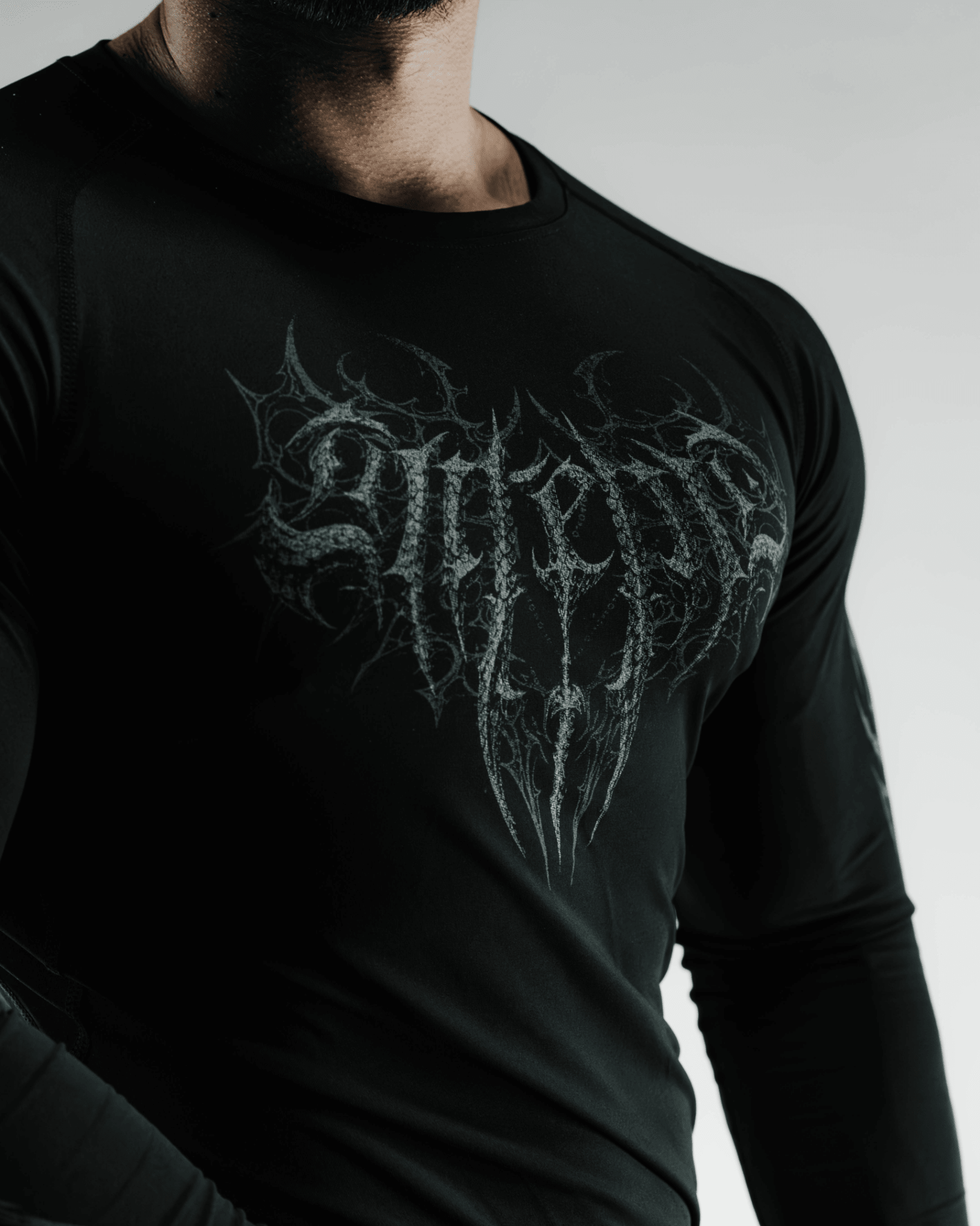 Black long-sleeve shirt with intricate white design on a plain background
