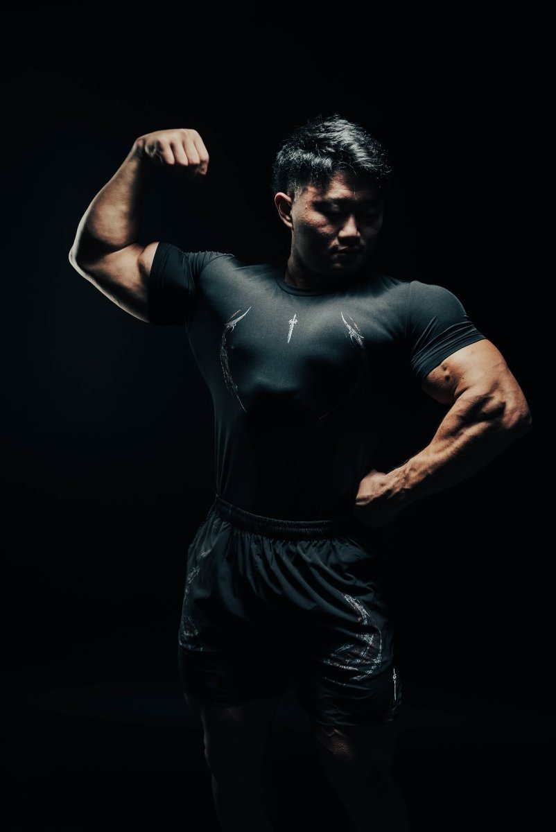 Man flexing his muscles against a black background