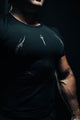 Person wearing a black t-shirt with white designs on a dark background