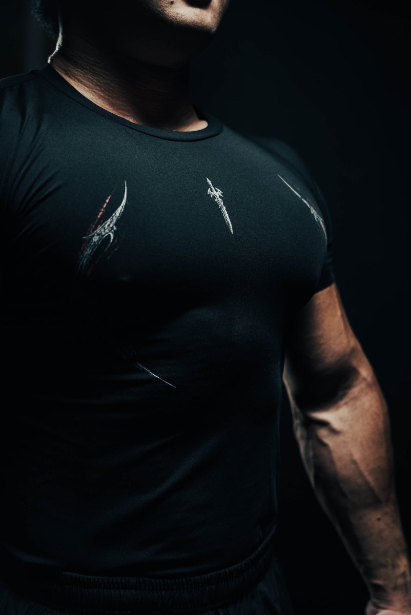 Person wearing a black t-shirt with white designs on a dark background