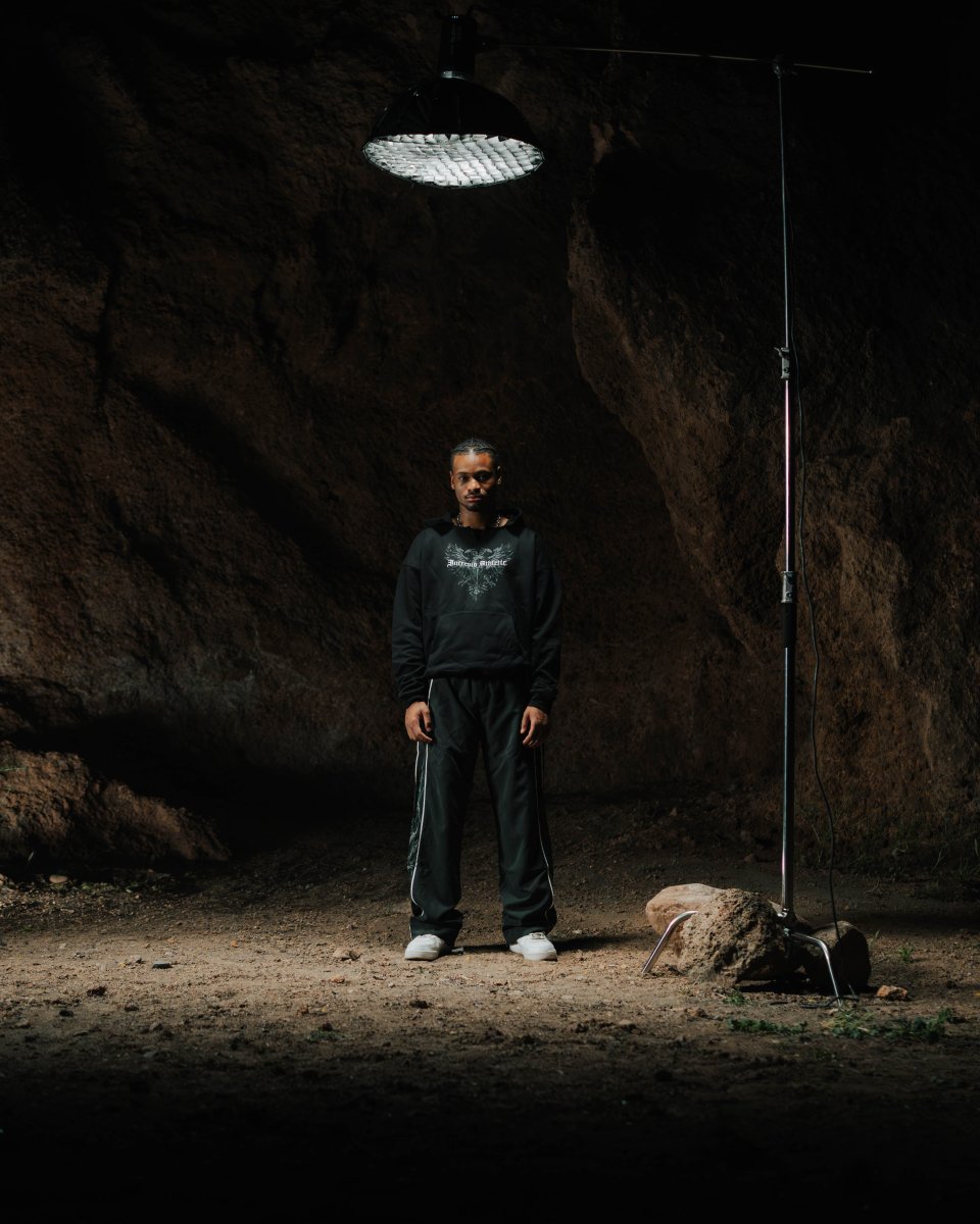 Person standing in a dark cave with a light fixture above