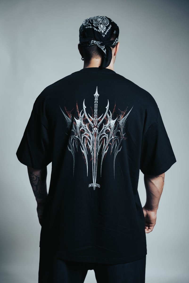 Person wearing a black t-shirt with a white graphic design on the back, standing against a plain background.