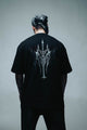 Person wearing a black t-shirt with a white graphic design on the back, standing against a gray background.