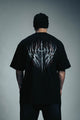 Person wearing a black t-shirt with a white design on the back against a gray background