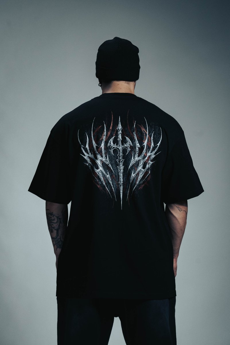Person wearing a black t-shirt with a white design on the back against a gray background
