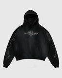 A black vintage hoodie with a graphic print on the front and sleeves, featuring a hood and a kangaroo pocket.