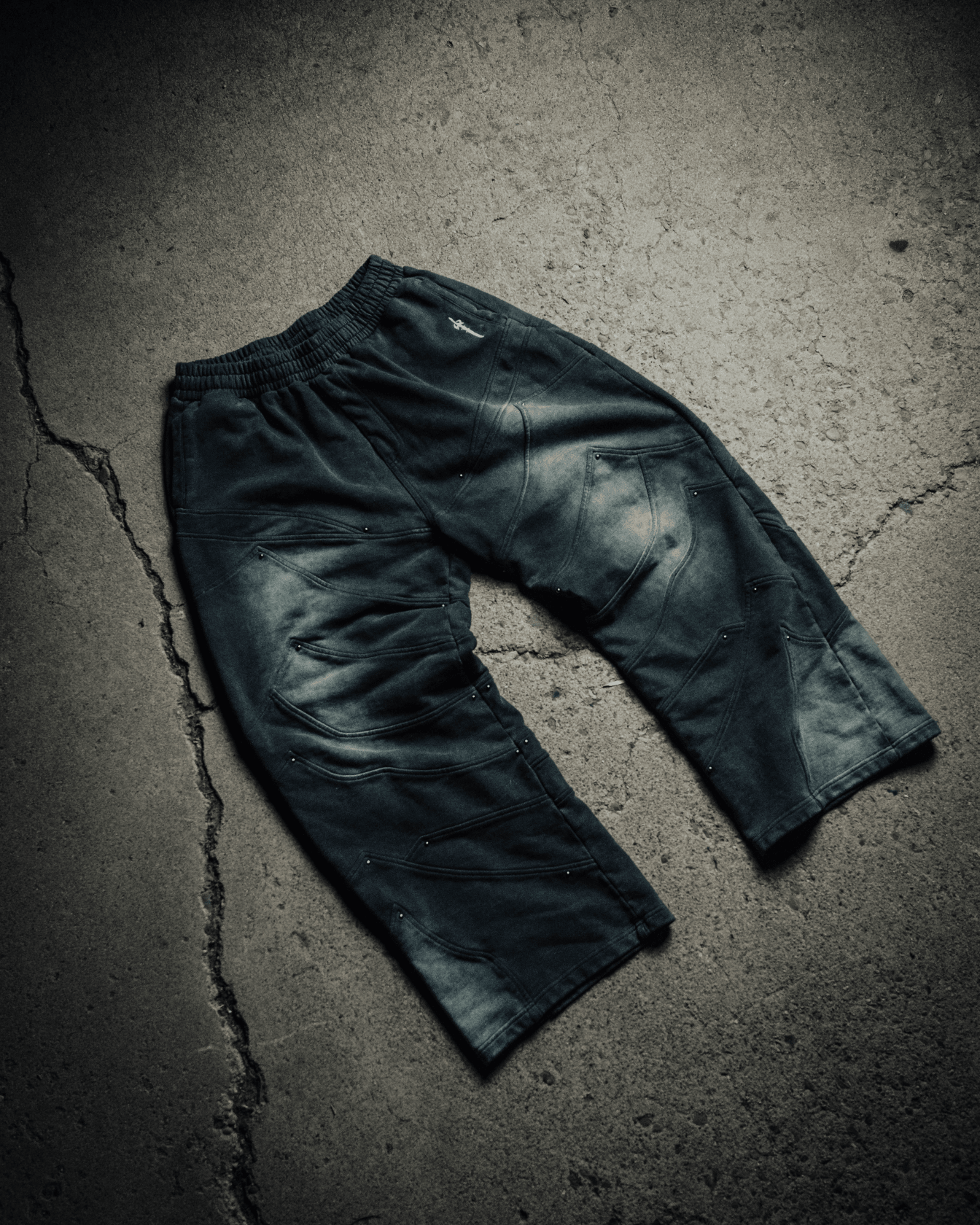 Dark green pants on a textured gray surface