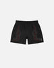 Black shorts with red tribal designs on a white background
