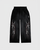 Black pants with white abstract designs on a light gray background