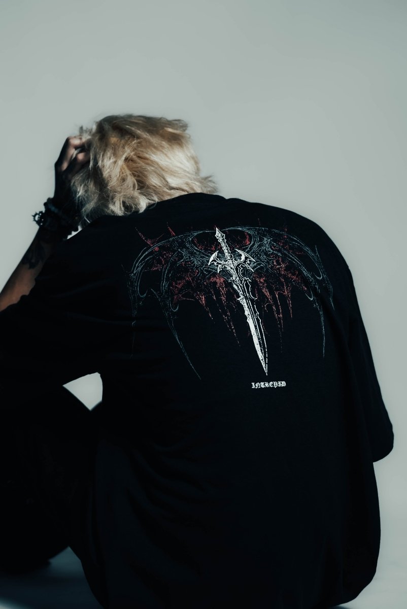 Person wearing a black t-shirt with a graphic design on the back against a plain background