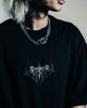 Person wearing a black t-shirt with a graphic design, standing against a neutral background.