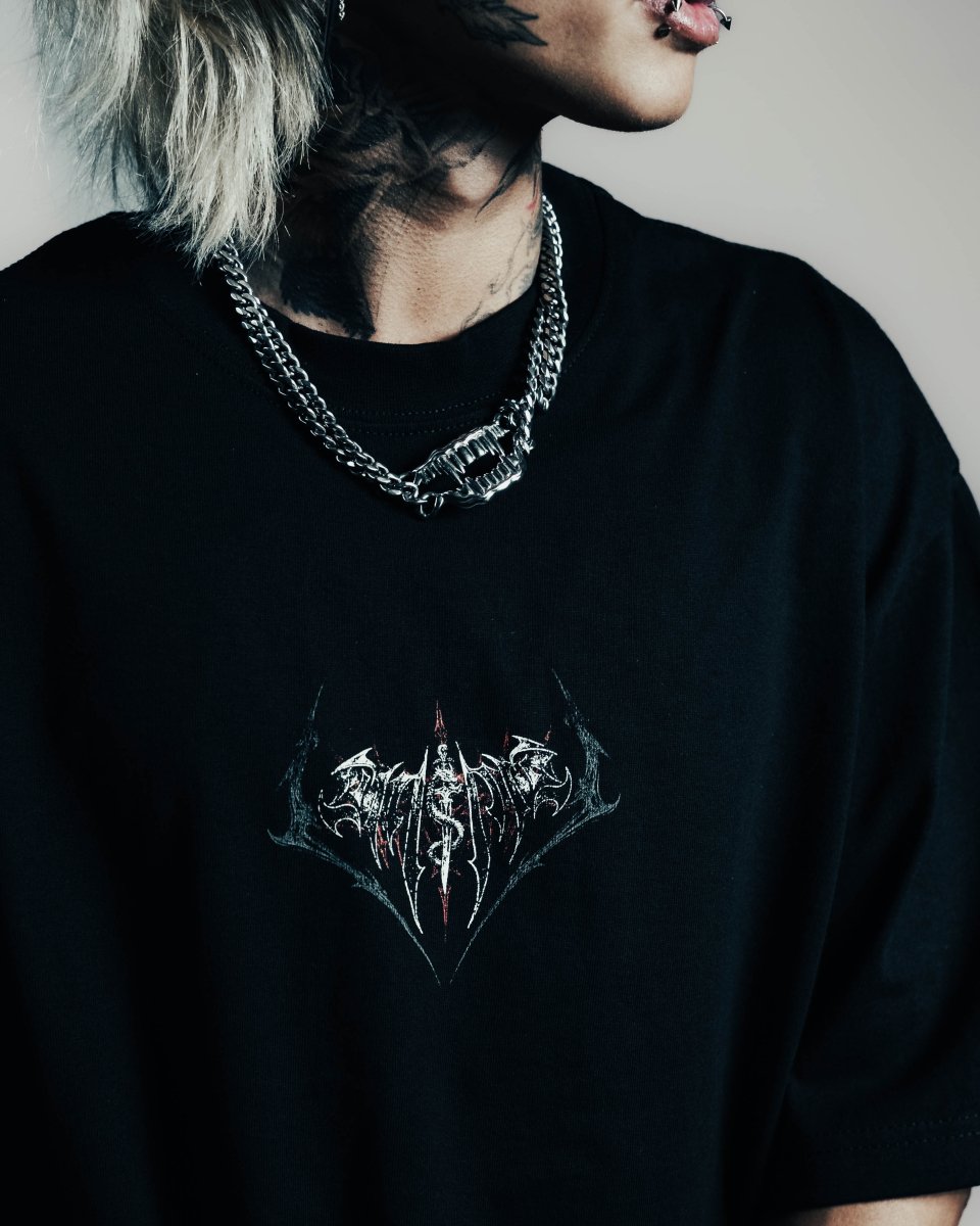 Person wearing a black t-shirt with a graphic design, standing against a neutral background.