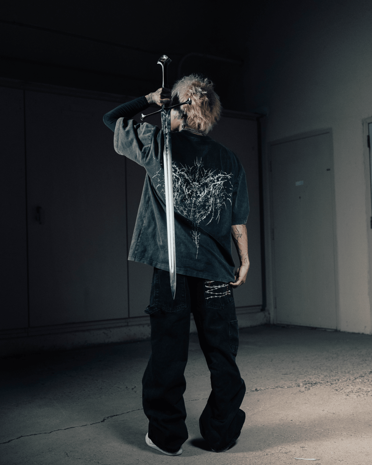 Person holding a sword in a dark room
